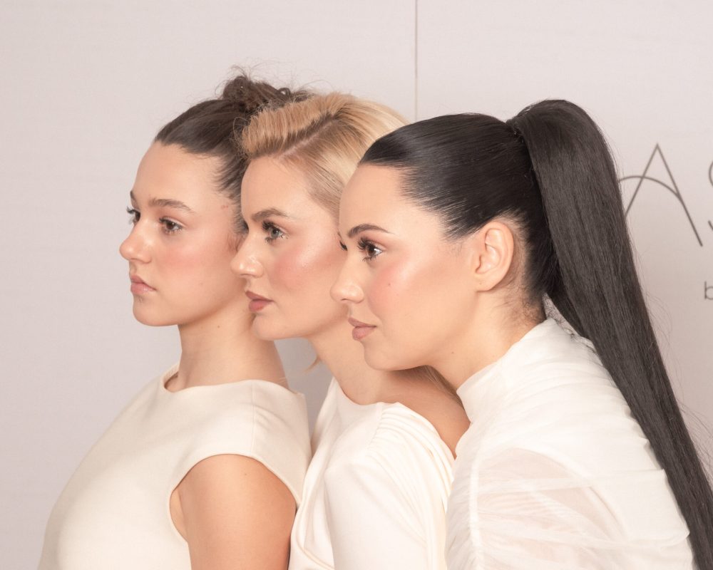 Tri devojke različitih profila i tipova kose sa blistavim tenom ispred Jasmin beauty centar logoa.